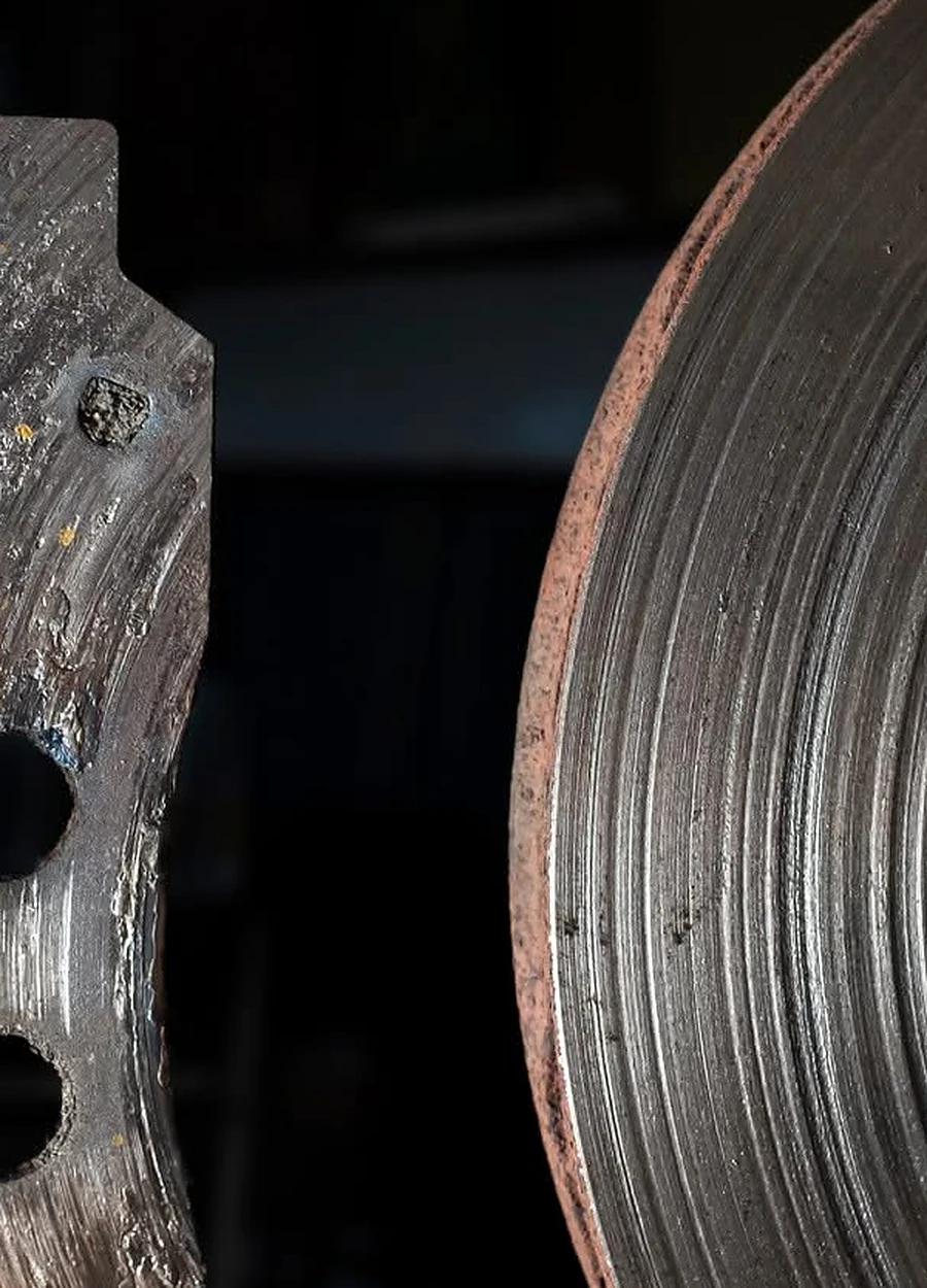 Close view of a worn brake rotor and brake component