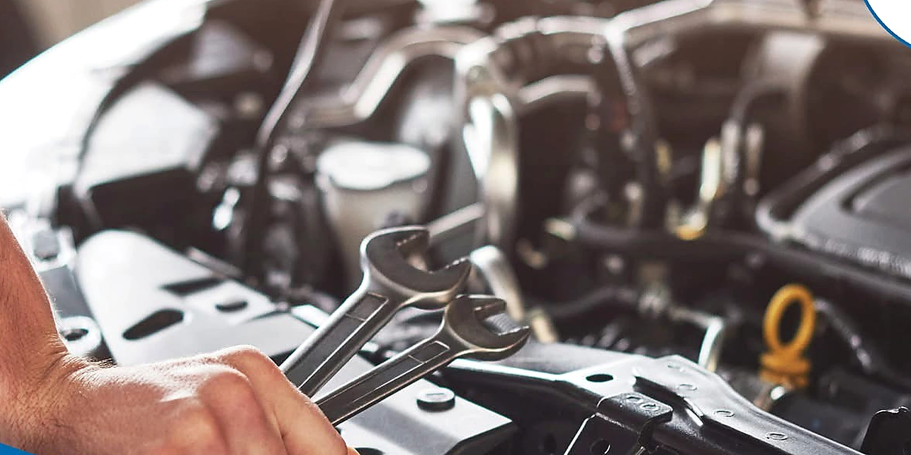 Hands using a wrench during under-hood repair work